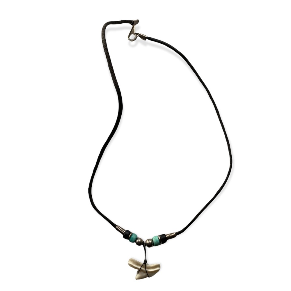 Shark tooth necklace with blue, black, and metal beads on cord.